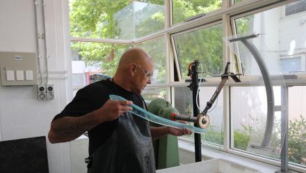 Shane sanding glass. Photo by Julia Boyd/ ANU